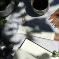 Requiem Incense Company Incense Sticks flat lay with incense sticks, book, vine, and coffee on grey background