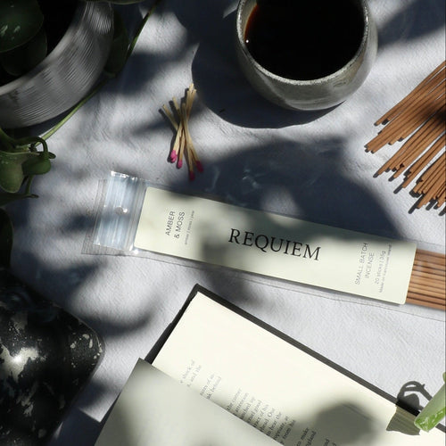 Requiem Incense Company Incense Sticks flat lay with incense sticks, book, vine, and coffee on grey background
