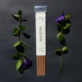 Requiem Incense Company Book Boyfriend incense sticks with green leaves and purple flowers on a dark background